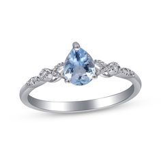 a white gold ring with an oval cut blue topazte and diamonds on the sides