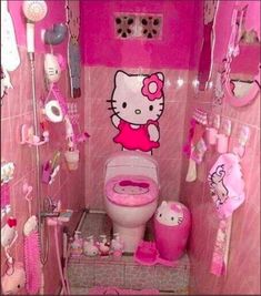 a pink bathroom with hello kitty decorations on the walls and floor, including a toilet