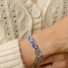 a woman's arm wearing a bracelet with blue beads