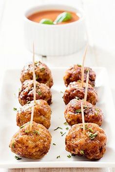 meatballs with toothpicks on a white plate