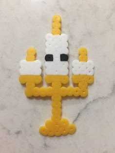 a yellow and white brooch sitting on top of a marble counter