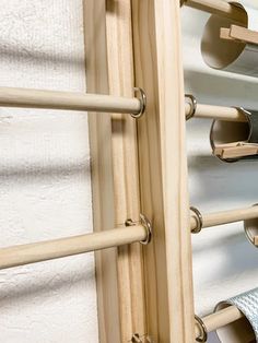 a wooden rack with several rolls of toilet paper hanging on it's sides,