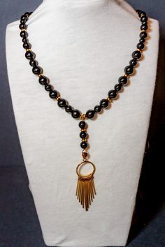 This necklace combines the timeless elegance of black and gold with the versatility to dress it up or down. Whether you're wearing it to a formal event or a casual outing, this necklace is sure to make a bold statement. Black Beaded Necklace For Formal Costume Jewelry, Elegant Adjustable Onyx Necklace, Elegant Gold Necklaces With Black Beads, Elegant Gold Necklace With Black Beads, Formal Black Beaded Necklace, Black Beaded Costume Jewelry Necklace For Formal Occasions, Formal Black Beaded Costume Jewelry Necklace, Formal Black Beaded Costume Necklace, Gold Beaded Necklaces With Black Beads For Evening