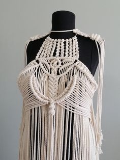 a white crocheted shawl on a mannequin headdress with beads and tassels