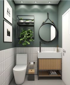 a bathroom with a toilet, sink and plant in the corner on the wall next to the mirror