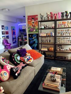 a living room filled with lots of furniture and shelves full of stuffed animals on top of them