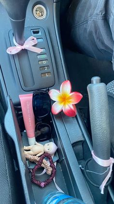 the interior of a car with various items in it and a flower on the dash board