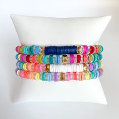 multicolored stretch bracelets on white pillow