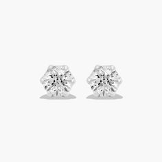 a pair of diamond stud earrings on a white background with the top one in view