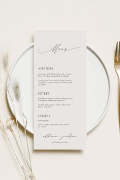 a white plate with a silver fork and knife on it next to a menu card