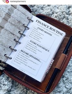 an open planner sitting on top of a carpet next to a pen