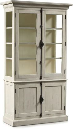 an old white china cabinet with glass doors and black knobs on the bottom shelf