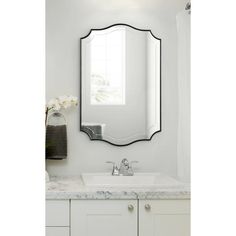 a bathroom with white cabinets and a large mirror