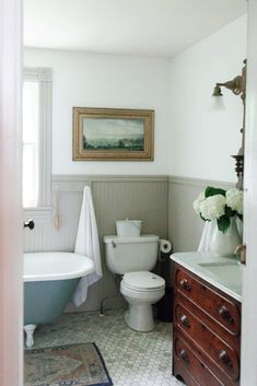 a white toilet sitting next to a bath tub in a bathroom