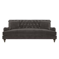 a black velvet couch with buttons on the back and arms, in front of a white background