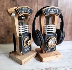 two wooden speakers with headphones on top of each one, sitting side by side