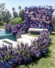 an instagram photo with purple flowers on it and a bench in the grass next to a pool