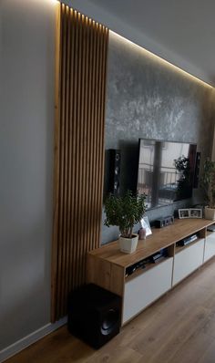 a living room with a large television on top of a wooden entertainment center next to a wall mounted flat screen tv