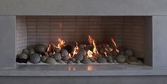 a fire place with rocks in it and flames coming out from the top one side