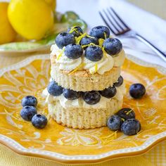 three cakes with blueberries and lemons on a yellow plate