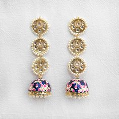 Accessorize your outfit with our cute navy blue Rasika jhumka earrings, a meenakari-style, hand-painted jhumka with embedded gemstones and pearls. Did you know that the word "rasika" means passionate in the Sanskrit language? Specifications Materials used: meenakari, jhumka, gemstones, pearls At Romikas, we pride ourselves on the craftsmanship and high quality of our jewelry, designed to enhance your natural beauty. Please contact us with any questions. Festive Blue Tilla Jhumkas, Blue Jhumkas For Festive Occasions, Blue Tilla Jhumkas For Festivals, Blue Jhumkas With Tilla For Festivals, Blue Meenakari Jhumkas As Gifts, Festive Blue Chandbali Jhumkas, Blue Chandbali Jhumkas For Diwali, Blue Jhumkas For Diwali, Traditional Blue Jhumkas For Festivals