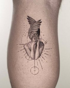 a woman's thigh with a tattoo design on her leg and the image of a bird flying over her head