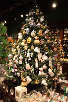 a christmas tree is decorated with teddy bears and other holiday decorations in a store display