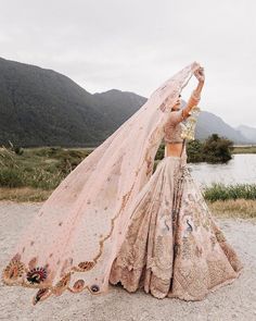 a woman in a wedding dress is holding her veil over her head