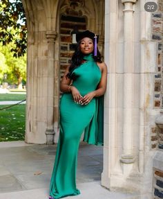 a woman in a long green dress posing for the camera with her hands on her hips