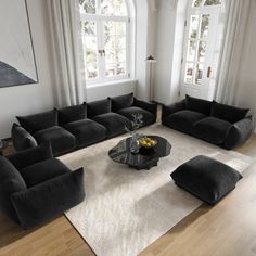 a living room filled with black couches and chairs