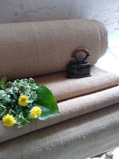 a bouquet of yellow flowers sitting on top of a couch next to a small iron