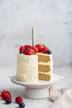 a cake with white frosting and berries on top