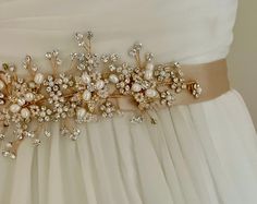 a bridal belt is adorned with pearls and crystal stones, as well as flowers