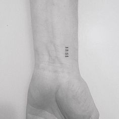 a black and white photo of a person's wrist with the word tell on it