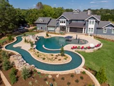 an aerial view of a home with a pool in the middle and landscaping around it