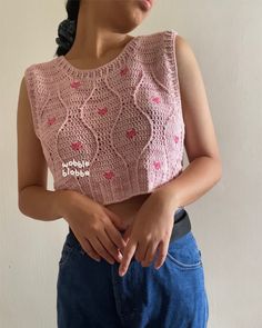 a woman is wearing a pink crochet top