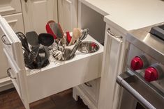 an open drawer in a kitchen filled with cooking utensils