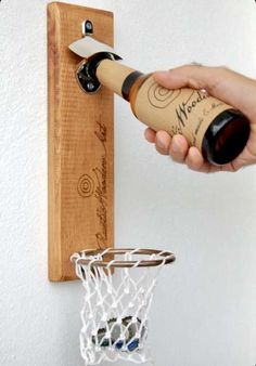 a person is holding a wine bottle in front of a basketball hoop with a cork on it