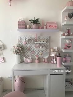 a white desk topped with lots of shelves filled with pink decorations and decorating items