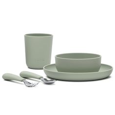 a set of green dinnerware with spoons and cups