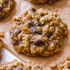 cookies with raisins and cranberries sitting on top of parchment paper, ready to be eaten