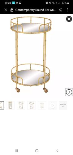 a gold metal bar cart with mirrors on the top and bottom shelf, in front of a white background