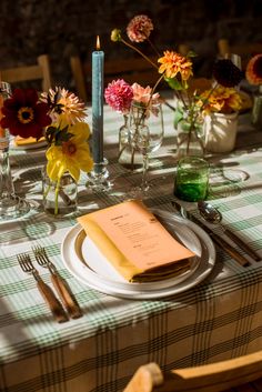 the table is set with flowers, candles and menu cards for dinner guests to enjoy