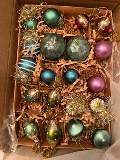 an open box filled with assorted christmas ornaments