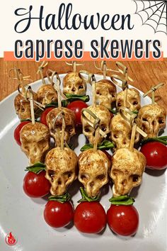 there is a white plate with tomatoes and skulls on skewers attached to them