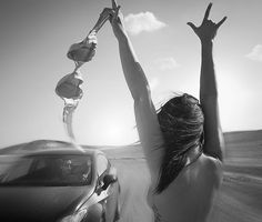 two women reaching up in the air to catch a frisbee on a desert road