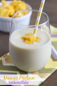 mango protein smoothie in a glass with a straw