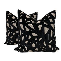 two black and white pillows sitting next to each other