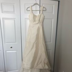 a white dress hanging on a closet door