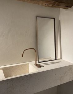 a bathroom sink with a mirror and faucet on it's side next to a window